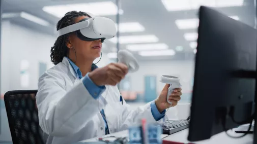 EIne Frau arbeitet am Schreibtisch mit einer VR-Brille