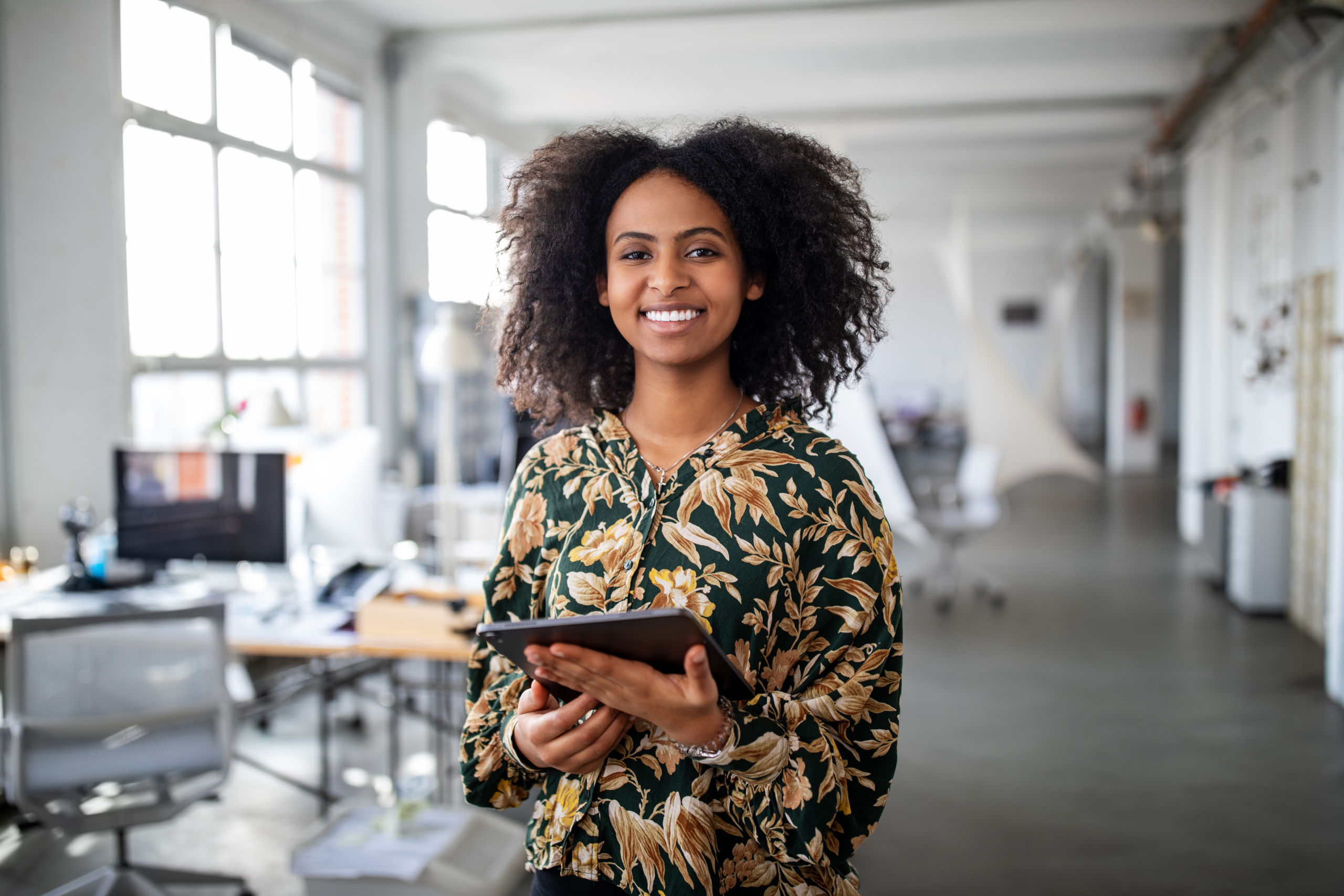 laughing woman with tablet in office