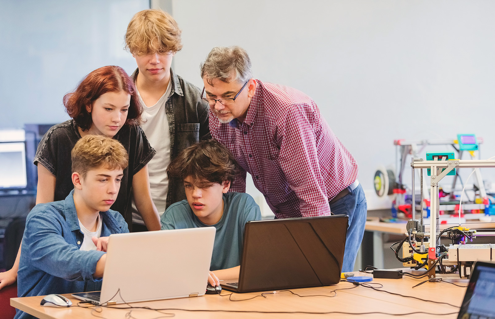 Teachers and students look at a computer