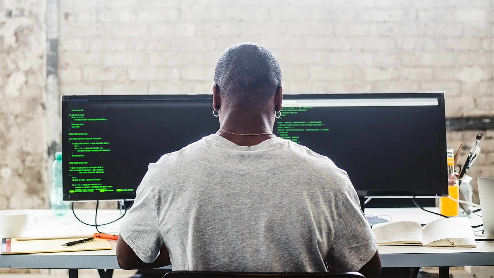 Photo of a man sitting at a computer and programming