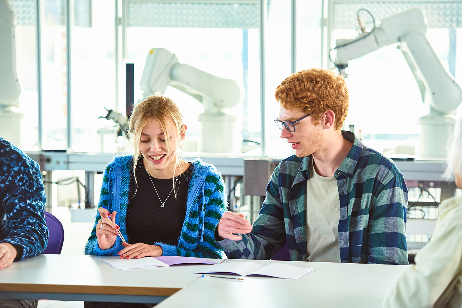 Zwei Personen sitzen in einem Meetingraum.