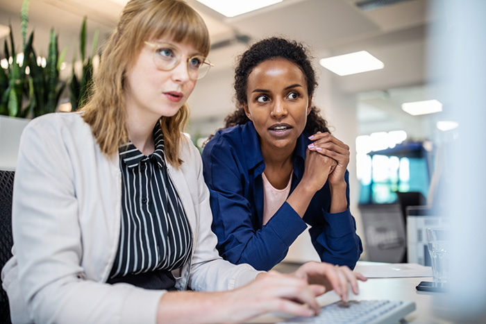 Two women at a computer desk in the office