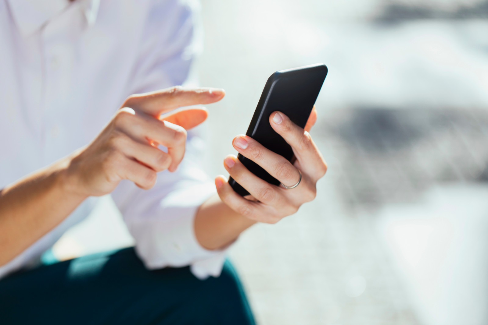 A Woman is tapping on a smartphone.