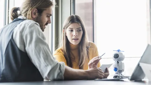 Woman and man working at one desk.