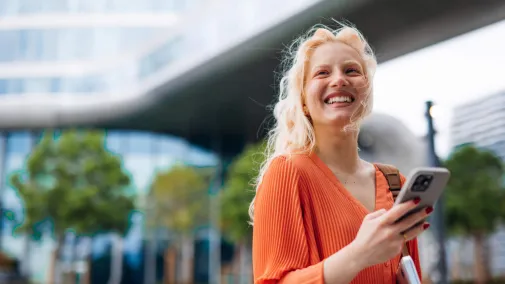 Eine junge Frau hält ein Smartphone in den Händen