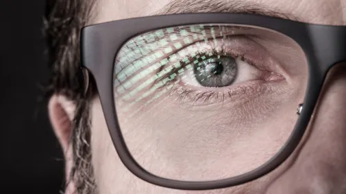 Ansicht einer Person mit Spiegelung auf dem Brillenglas