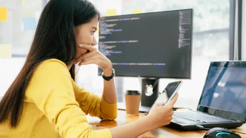 Eine Frau arbeitet am Tablet und am Computer.