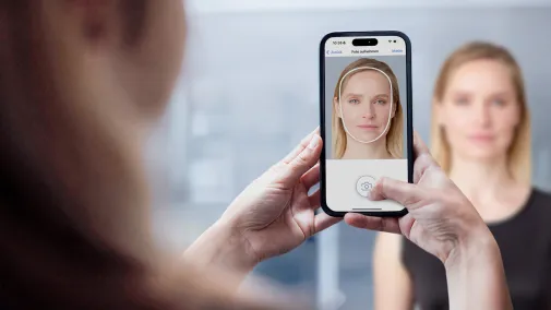 Eine Frau wird mit einem Smartphone fotografiert.