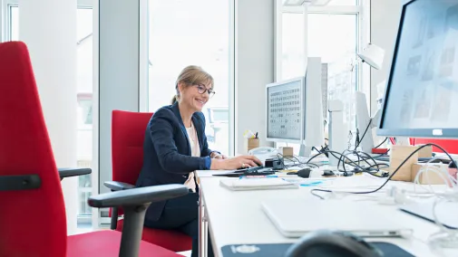 Frau sitzt am Computer im Büro