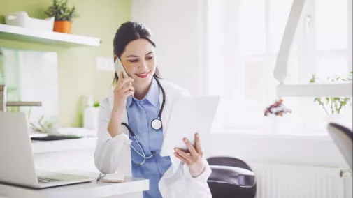 Frau Arzt sind mit Smartphone und Notebook in Praxis