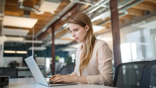 Frau arbeitet am Computer Eine Frau arbeitet im Büro am Computer