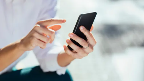 A Woman is tapping on a smartphone