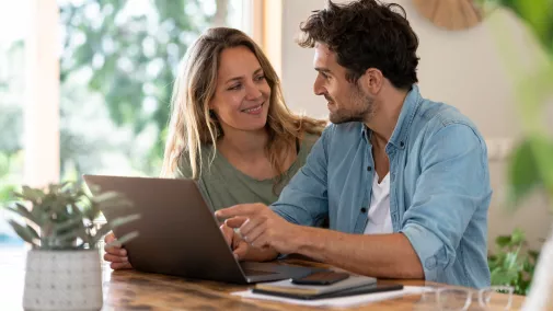 Frau Mann mit Tablet am Tisch zu Hause