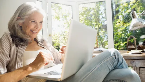 Frau Senior sitzt mit Notebook draussen Frau Senior sitzt mit Notebook draussen