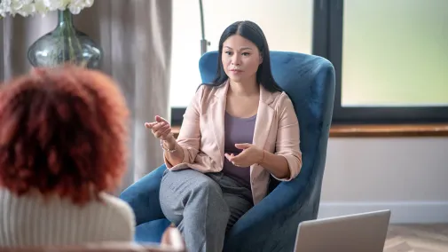 Ansicht von zwei Frauen die sich in einem Meeting gegenüber sitzen.