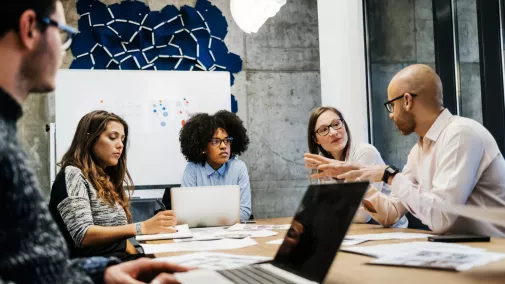 women men sitting on a table with notebook in office for business meeting