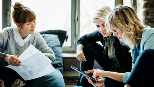women having business talk in hands paper and tablet at the office