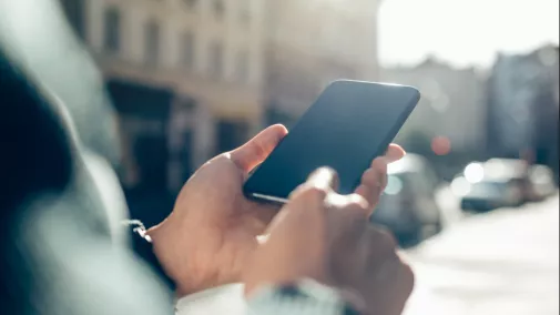 Detail Hand mit Smartphone draussen Detail Hand mit Smartphone draussen