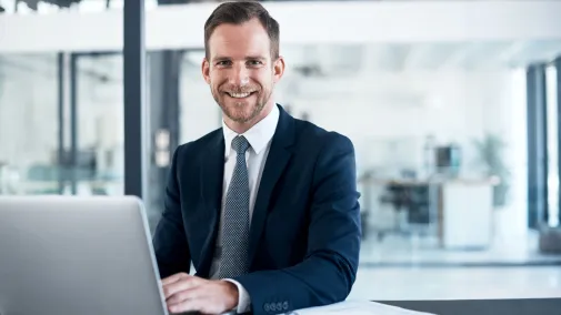 Businessmann arbeitet im Büro am Laptop