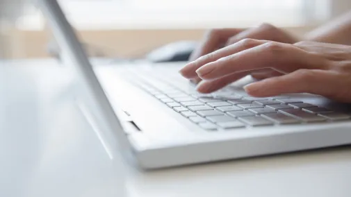 hands typing on laptop