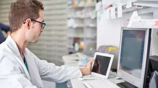 Mann Arzt am Computer mit Tablet im Labor Mann Arzt am Computer mit Tablet im Labor