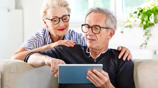 Rentner-Ehepaar mit Tablet in der Hand