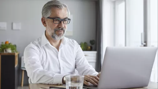 Mann sitzt am Notebook zu Hause Mann sitzt am Notebook zu Hause