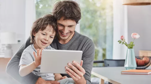 Mann Vater mit Kind am Tablet zu Hause Mann Vater mit Kind am Tablet zu Hause