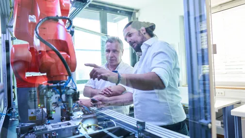 Personen arbeiten an einer Maschine.