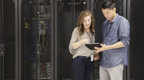 Woman and man standing in front of a server with a tablet