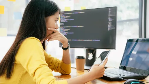 A woman works on her tablet and computer.