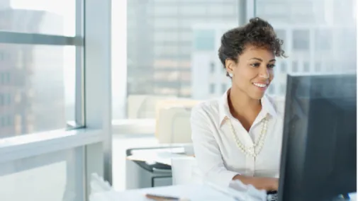 A woman is working on her laptop and smiling