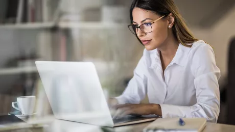 Frau tippt auf einem Laptop