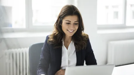 A woman works remotely on her laptop