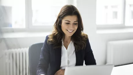 Eine Frau arbeitet remote an ihrem Laptop