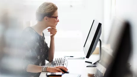 Frau arbeitet am Computer im Büro