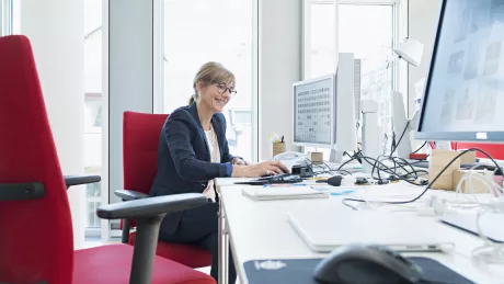 Frau sitzt am Computer im Büro