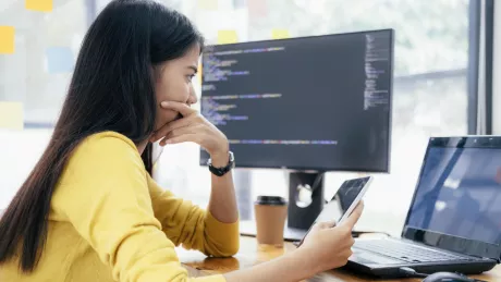 Frau am Computer mit Tablet im Büro