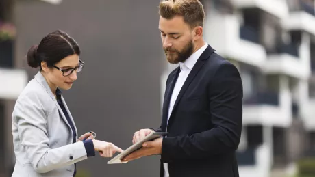 Frau und Mann mit Tablet draussen Unterschrift