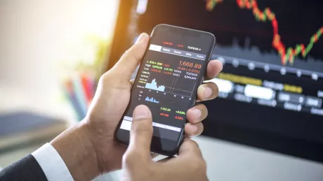 Mann und seine Hände schaut auf Smartphone Börse