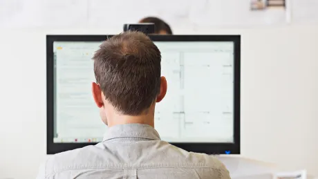 Man sits at computer and works