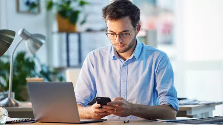 Mann sitzt im Büro am Arbeitsplatz.