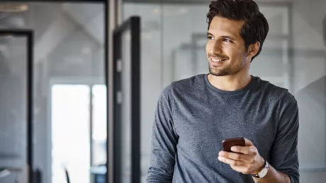 man with smartphone staying in office