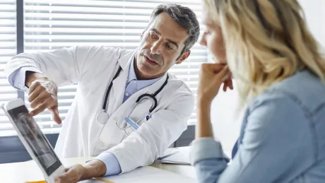 Doctor shows a patient X-ray images on a tablet