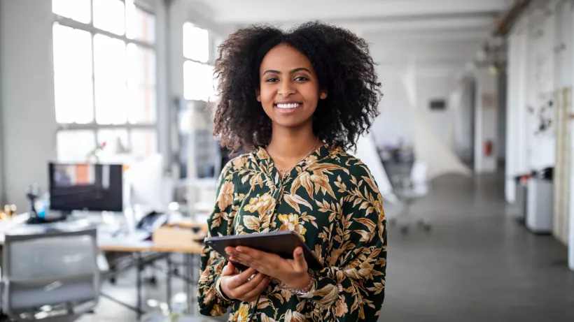 laughing woman with tablet in office