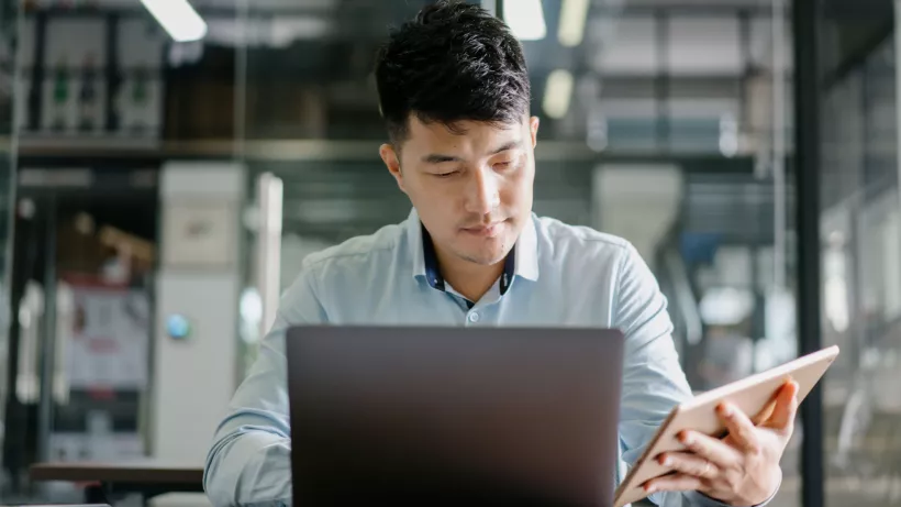 man works on laptop and tablet