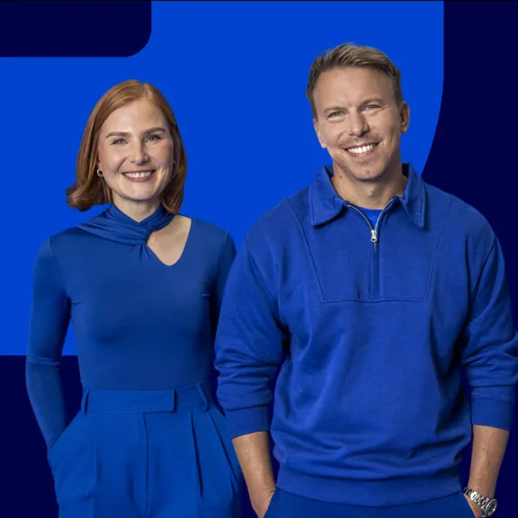 View of two employees against a blue background.