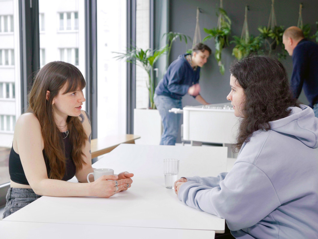 Two people are chatting at the break table.