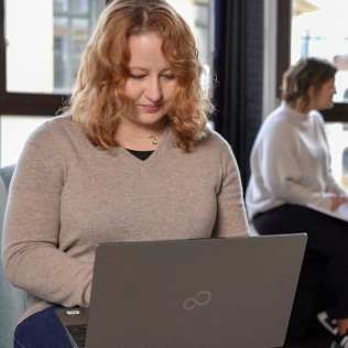 Sarah Hümmer, Softwaretester, schreibt an einem Laptop