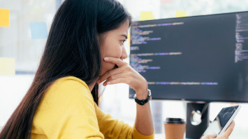 A woman is sitting at a computer in the office.